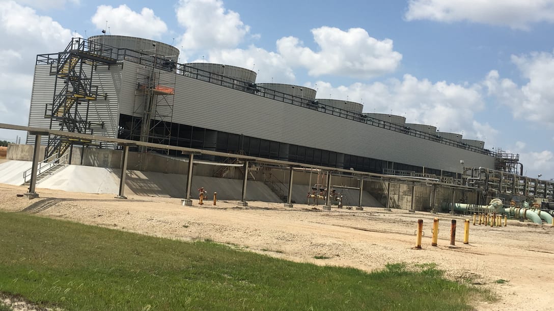 A multi-cell induced-draft cooling tower under erection, with its stair tower, fan decks and concrete basin